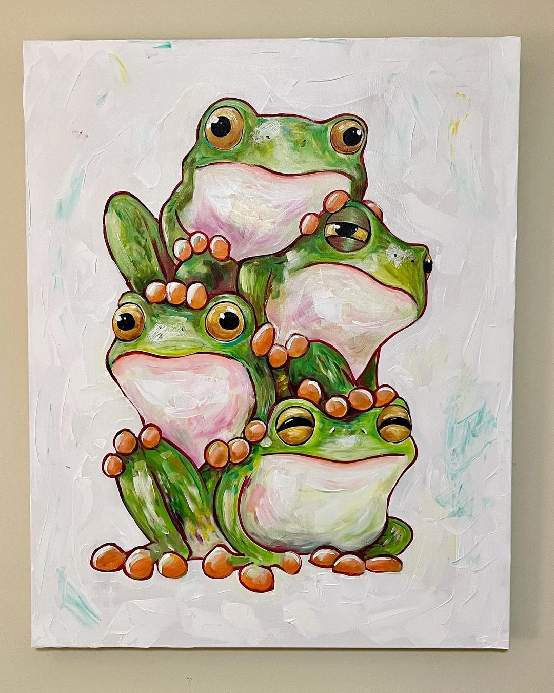 13. @james_powell_art painting of four green frogs stacked on top of another with orange feet and a white textured background