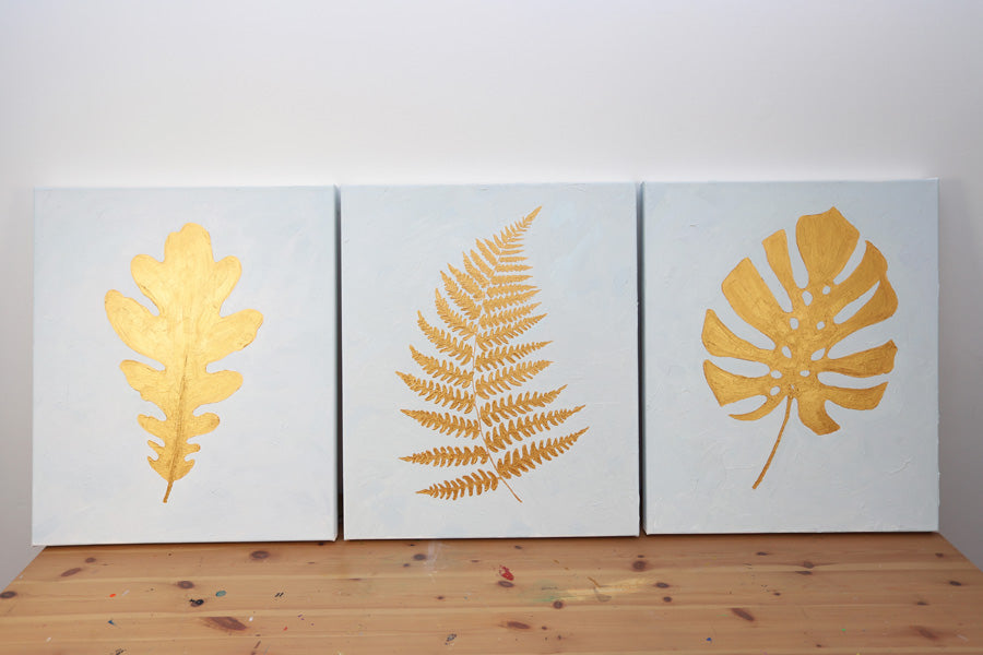 Three golden triptych artworks with various leaves on it.