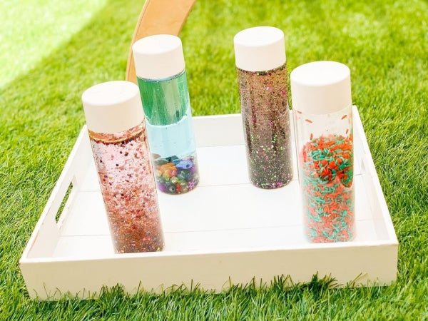 Four water shaker bottles filled with various glitters.