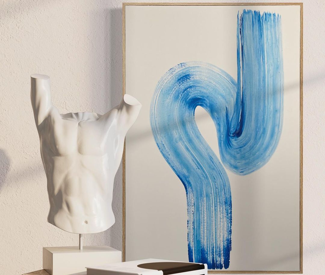 Blue brushtroke style artwork behind a white bodice statue