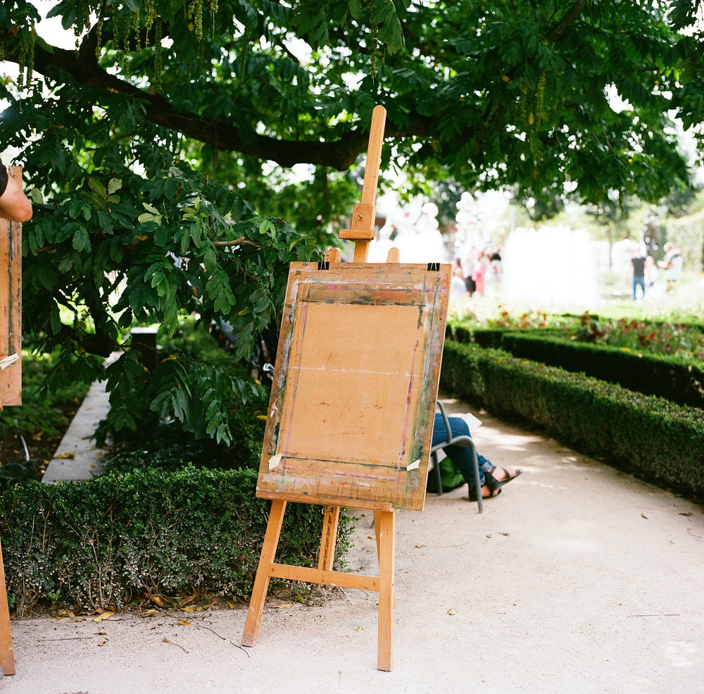 Wooden easel standing alone in a green park.