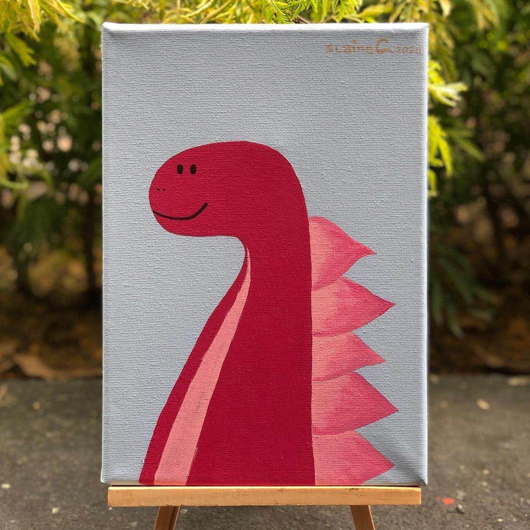 2. @elainecxxx acrylic painting of a red and pink dinosaur on a canvas, placed on a small easel