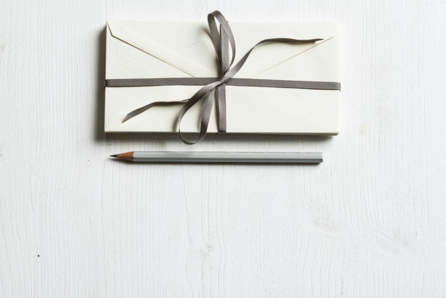 Envelopes bundled with string and a wooden graphite pencil.