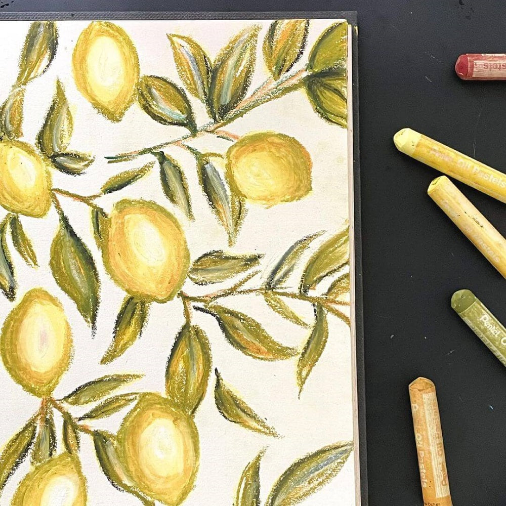 Oil pastel drawing of lemons on a sketch book.