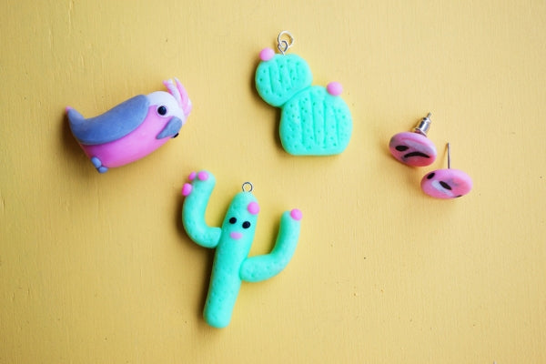 Four cute polymer clay jewellery pieces of a cactus and a bird.