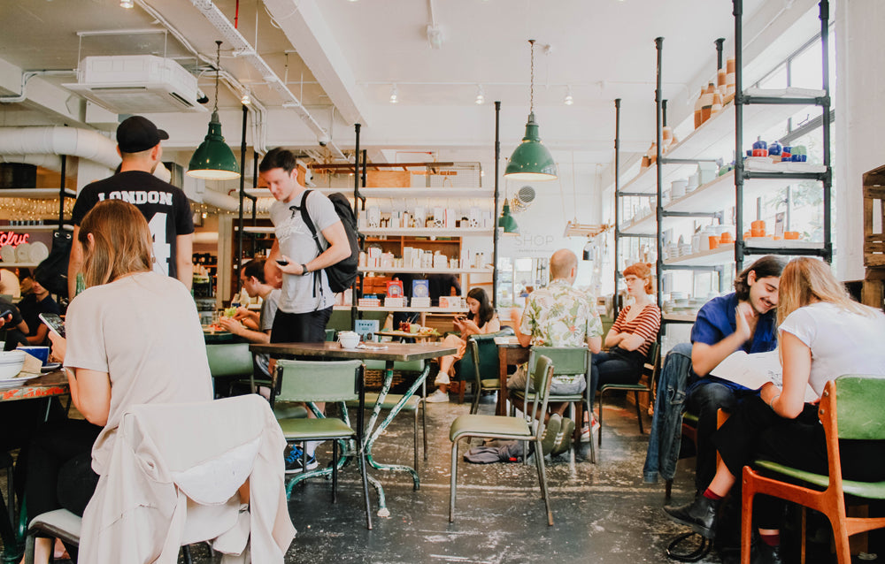 People socialising in a busy, city cafe.