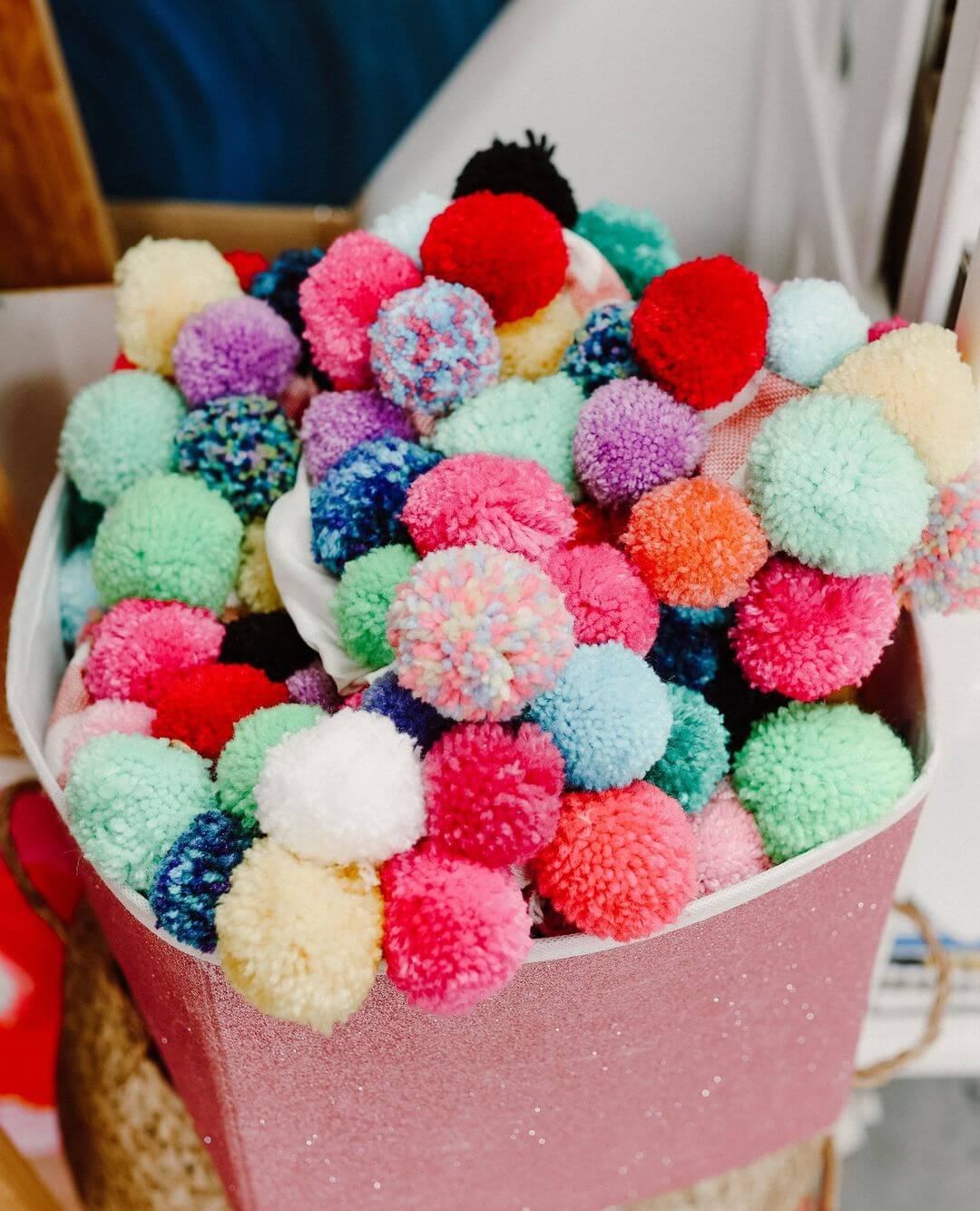 3. A glittery pink bucket filled with coloured pom poms.