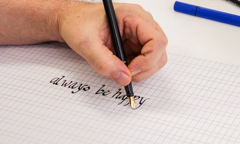 Hand changing the calligraphy pen's nib.