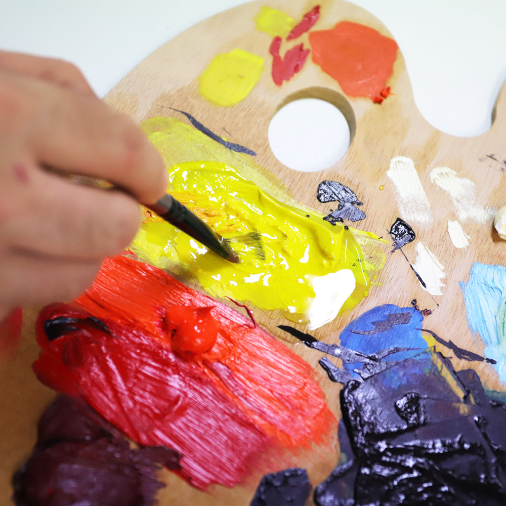 3. Oil medium being mixed into oil paints on a wooden palette