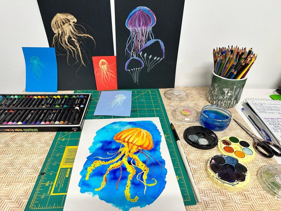 Watercolour artwork of a yellow and orange jellyfish on a blue background