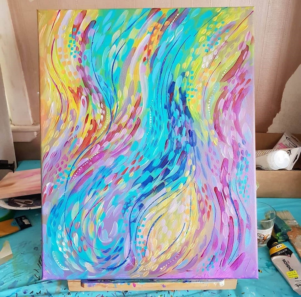 Abstract rainbow swirling in one direction of bright colours on canvas.