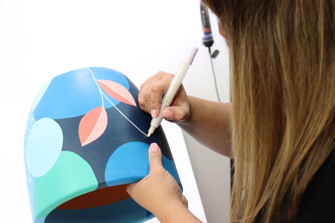 4. Ann Nguyen from the Artful Grimmer acrylic pen painting a pot with a bright leaf pattern