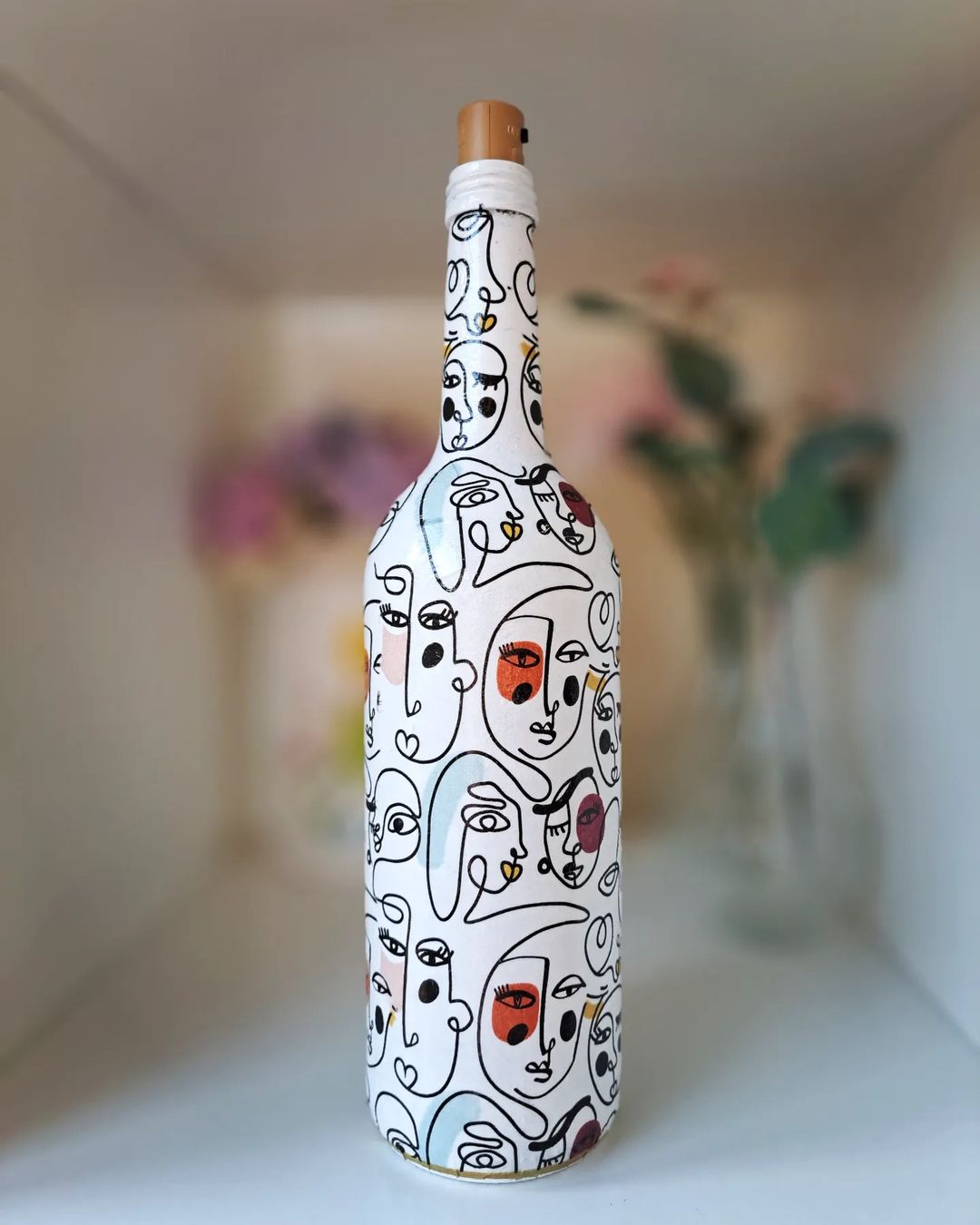 4. Bottle decorated with abstract linework faces