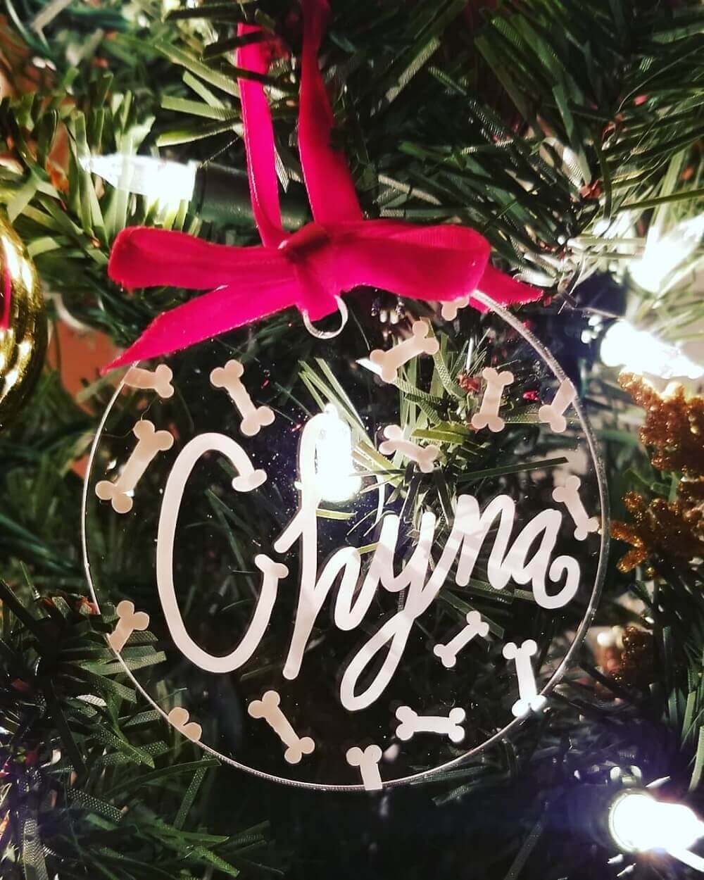Clear bauble with pet name hanging on a Christmas tree.