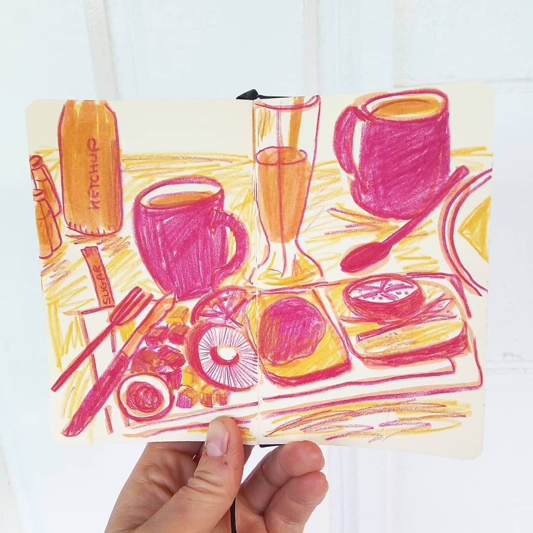 Hand holding a coloured breakfast still life drawing with pink and orange coloured pencils.