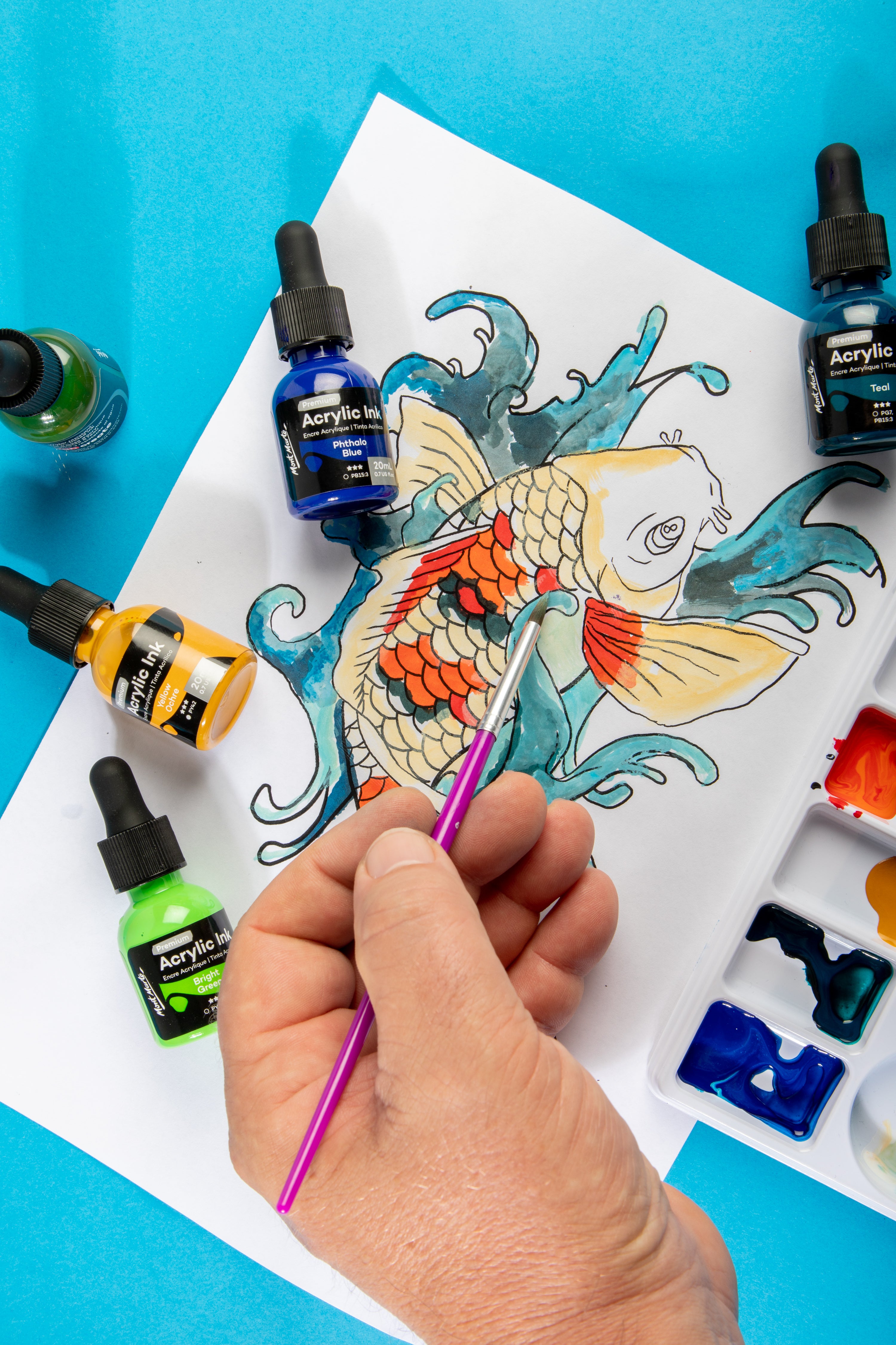 4. MM Acrylic Inks in use to colour in a koi fish picture with orange, grey, and yellow scales