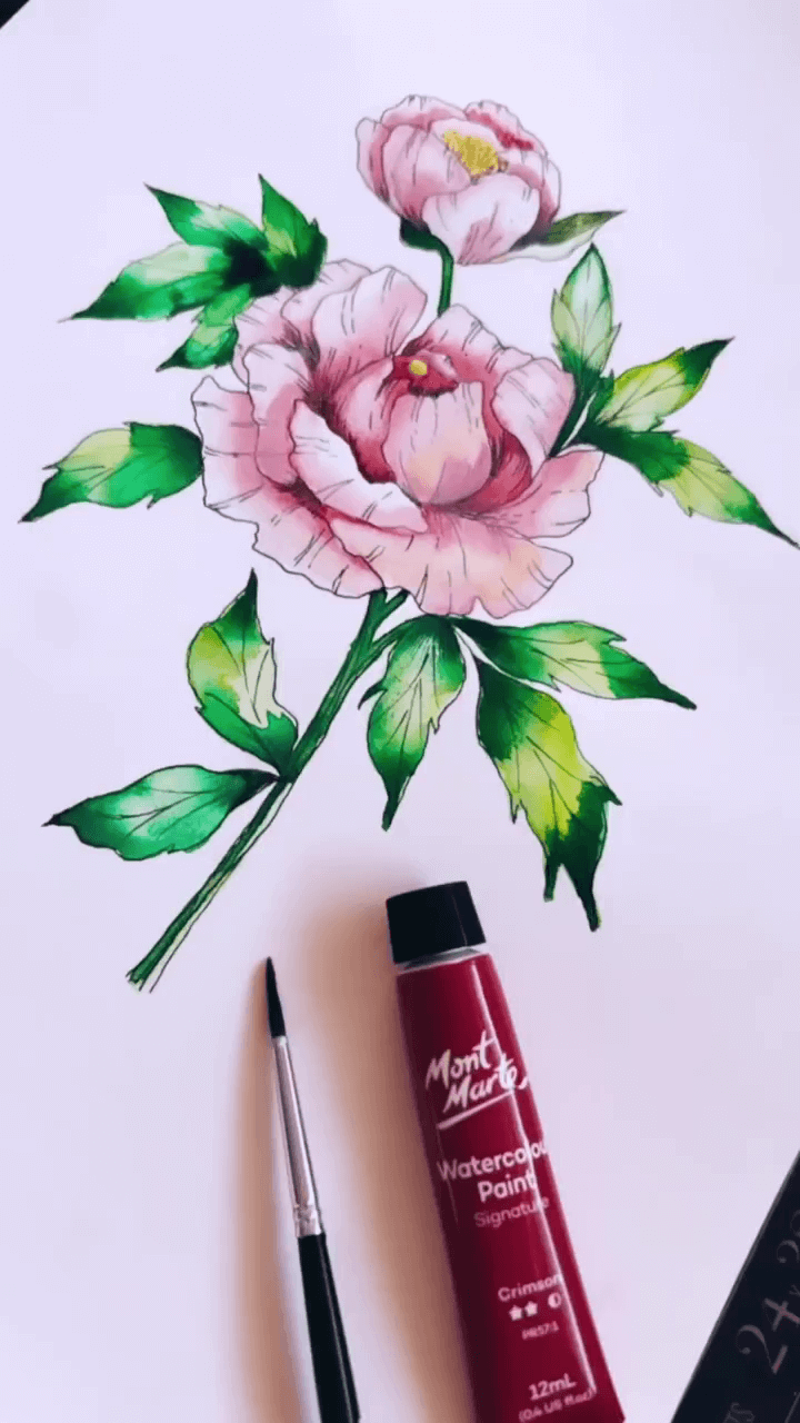 Pink flower drawn on watercolour paper and filled with colour next to a red Mont Marte watercolour tube and brush.