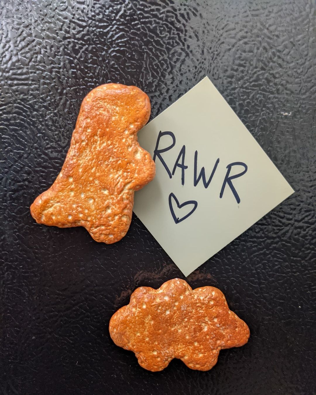 4. @inedible_treats dinosaur nuggets sculpture with a note saying 'rawr' underneath one of the nuggets