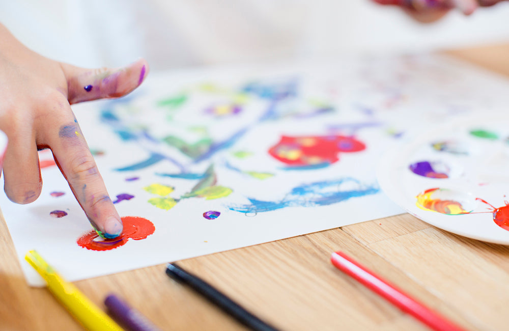 A child using their hands for painting.