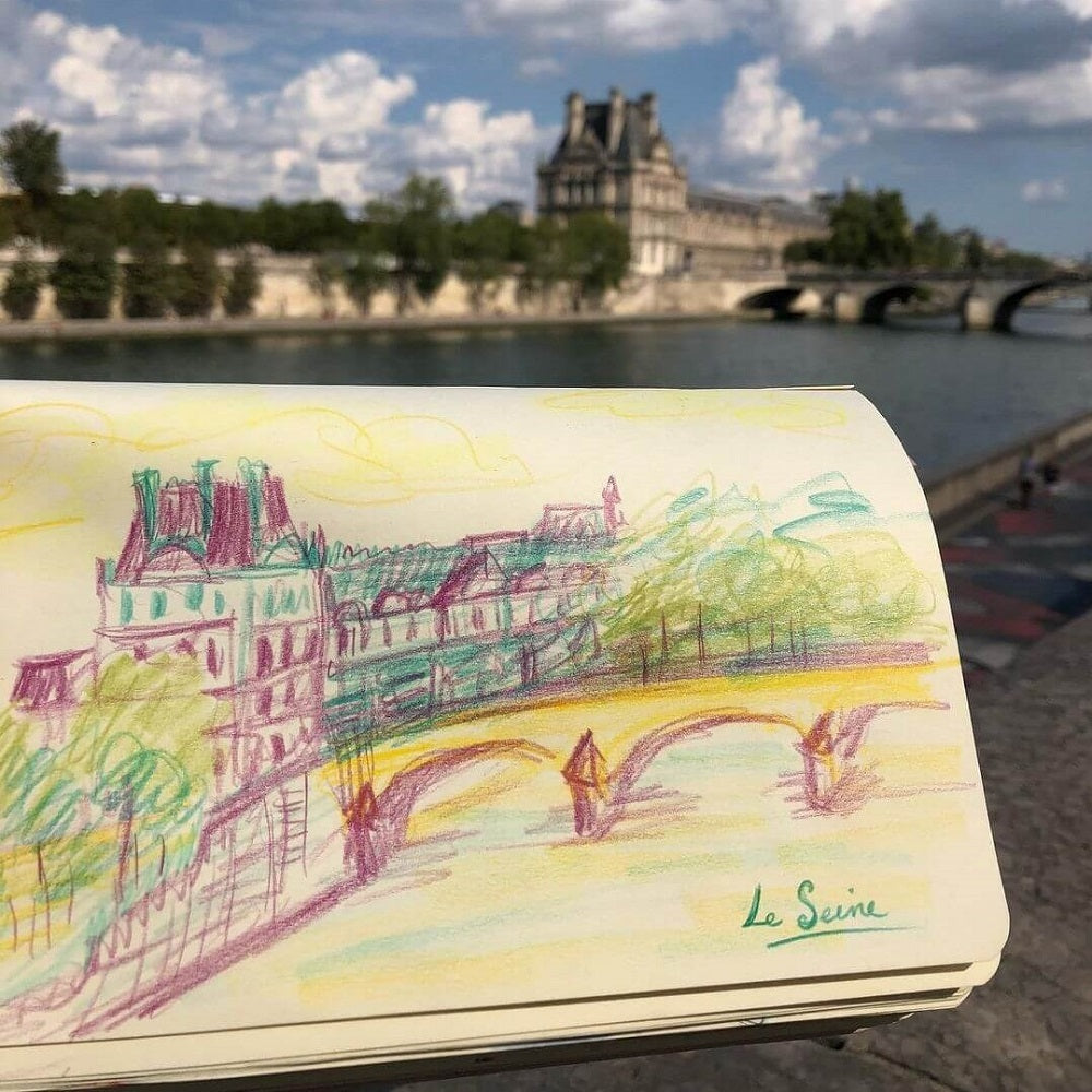 Sketchbook with colourful sketch of the Lourve in Paris.