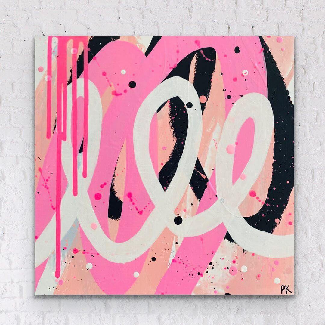 5. A pink and black cursive letter painted in a grafitti style, on a white wall.