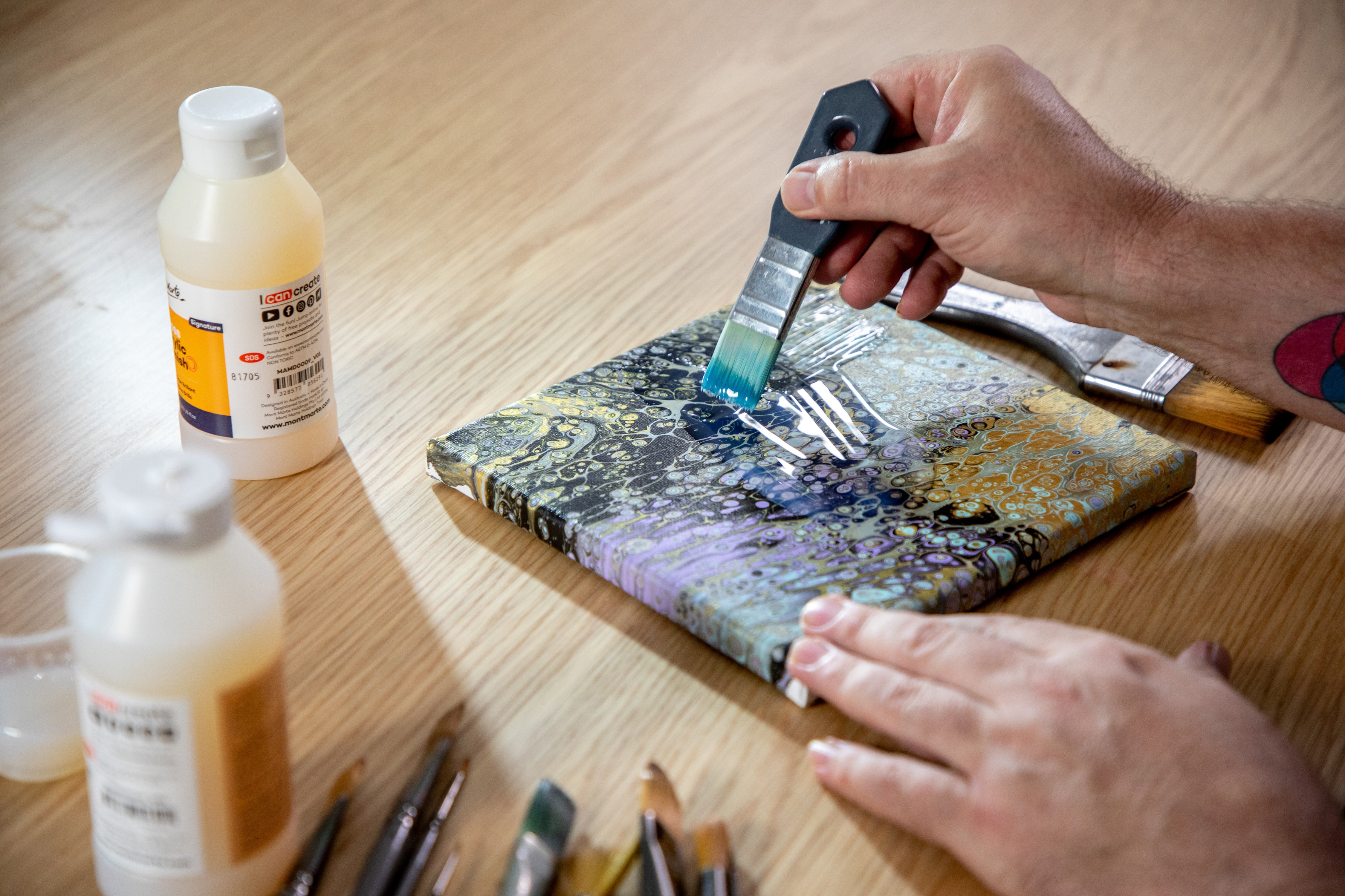 5. Acrylic Gloss Varnish in use on a purple, turquoise, and gold pour painting