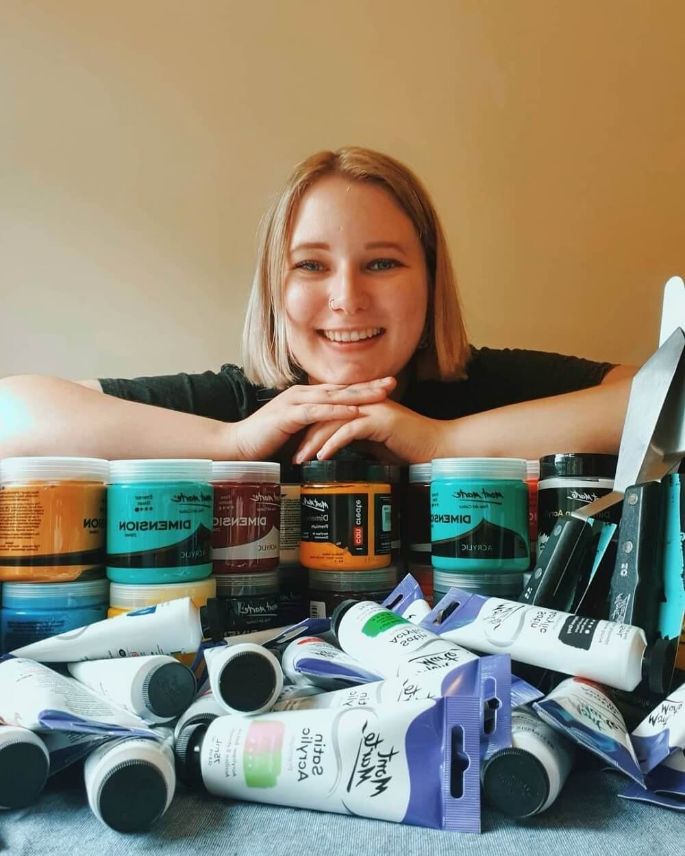 Jacklyn smiling at the camera surrounded by Mont Marte art products.