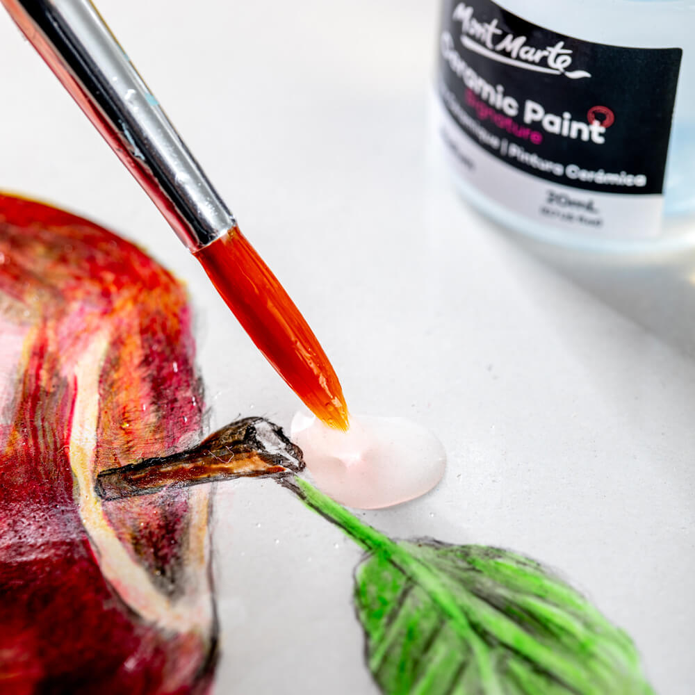 5. Mont Marte Ceramic Paint Medium being used on a ceramic painting of an apple