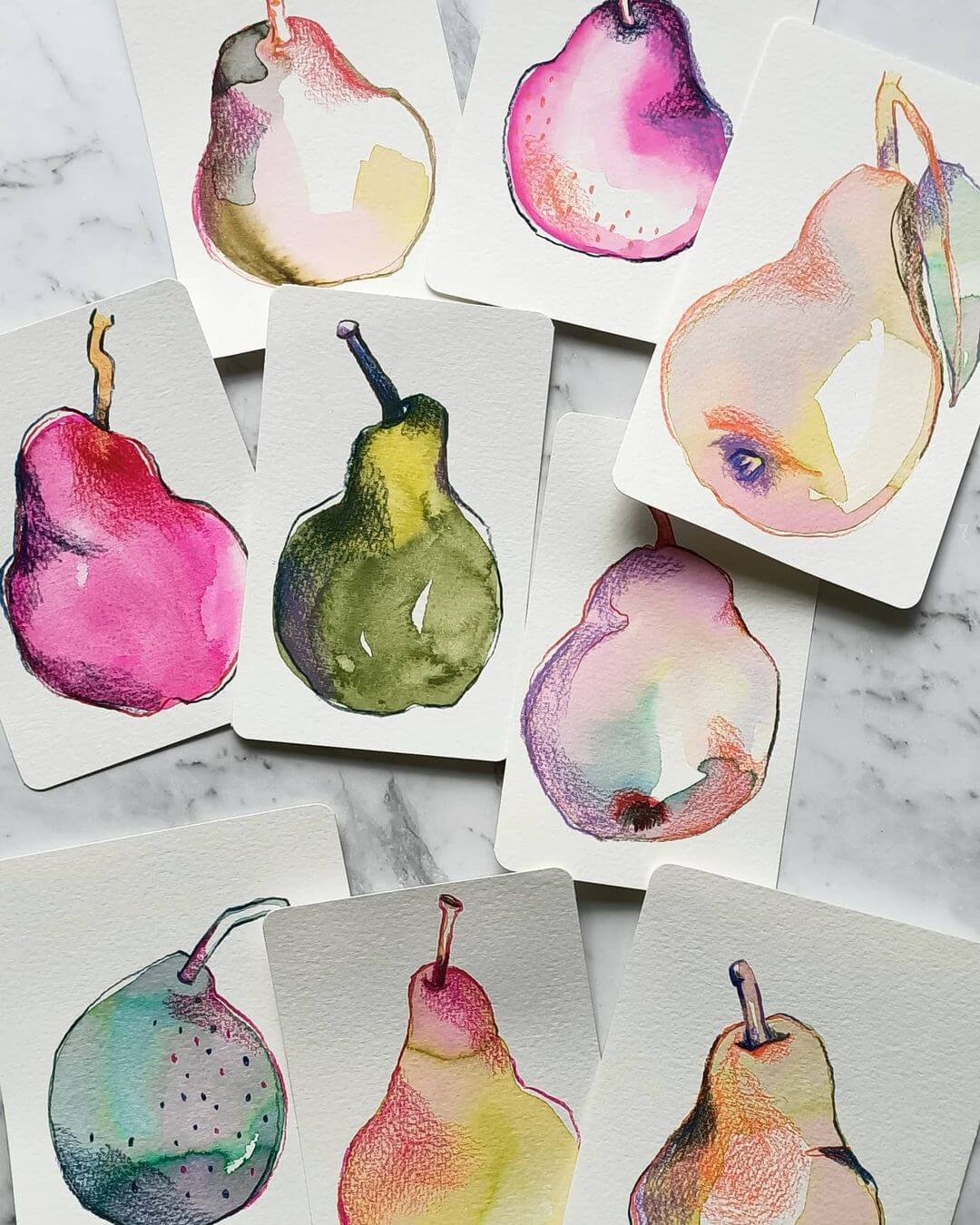 Nine small artworks of pears drawn in different colours on a marble table.