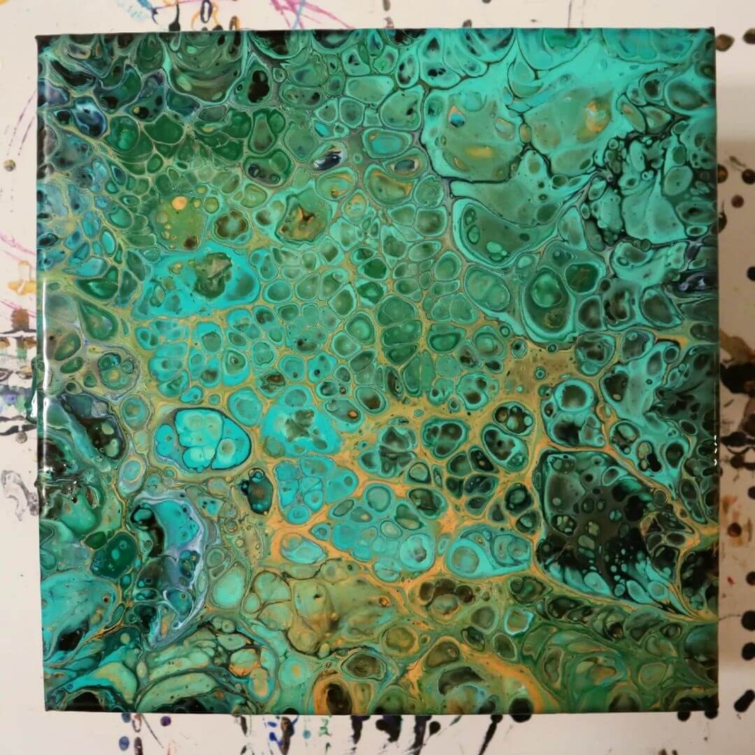 6. A canvas covered in green, light blue and gold acrylic paint with large cells on it.