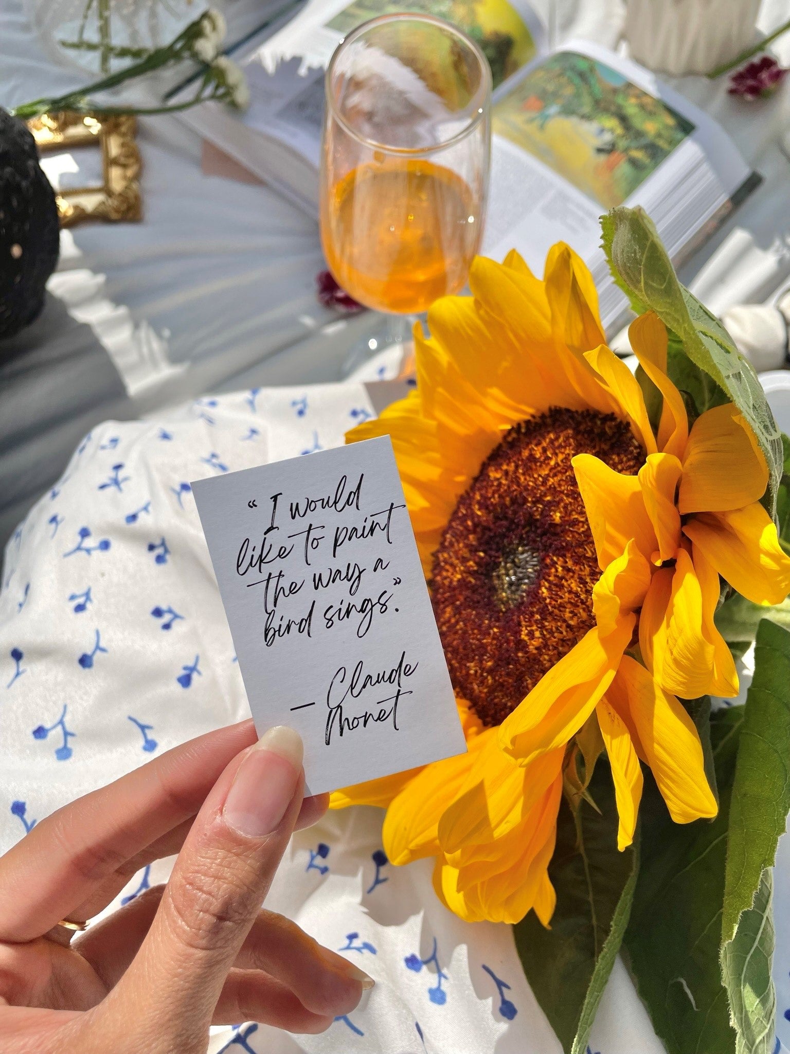 4. @Quinns_Arte holding an inspiring quote about painting in front of a sunflower