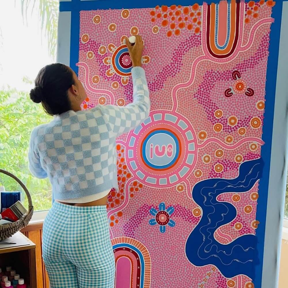 Ryhia in blue painting with pink and blue dots and waves on canvas