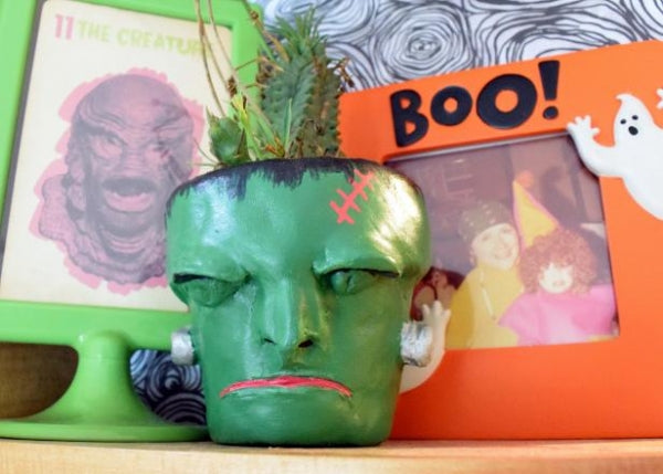 Frankenstein's monster made as a pot plant using air dry clay behind a lifestyle background.