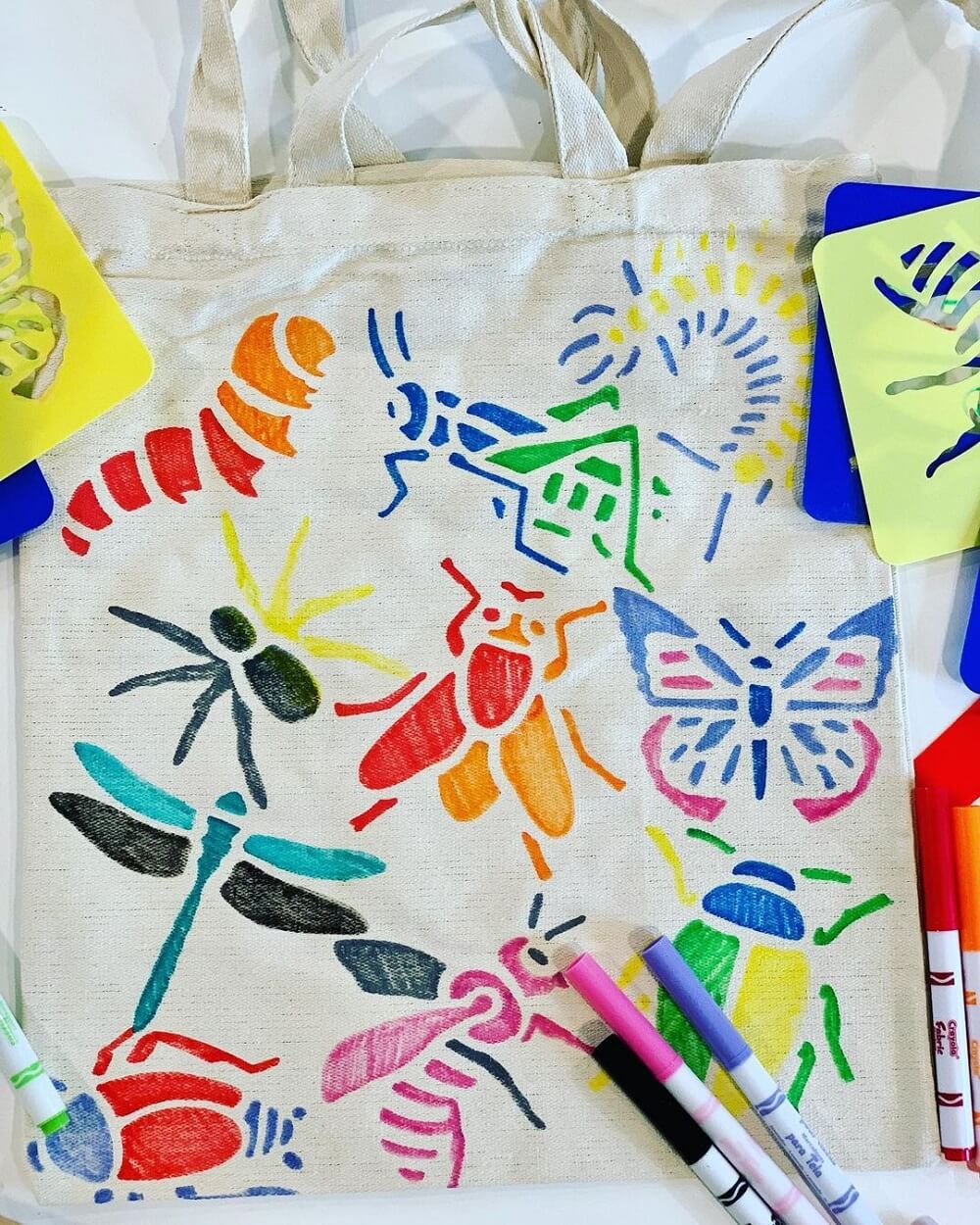 Bright coloured insect drawings drawn on to a canvas bag.