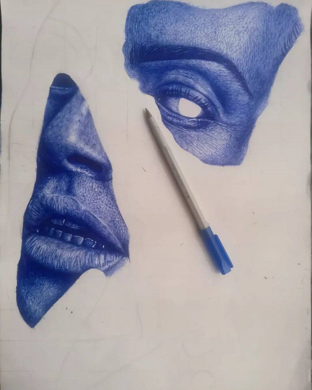 Progress photo of a drawing of a face in blue pen.