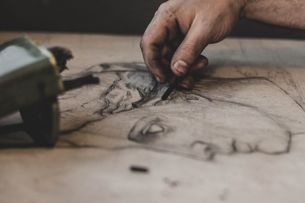 Messy hands blending out a charcoal work