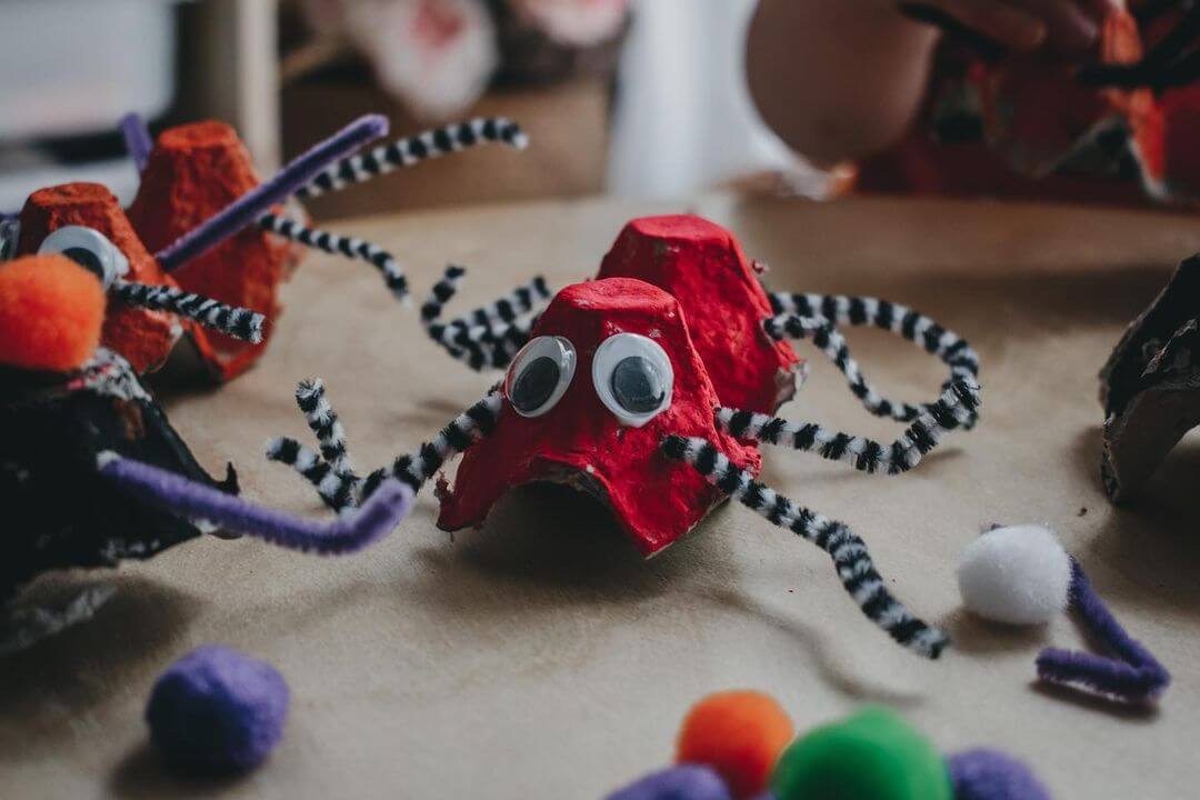 A spider made from an egg carton with pipe cleaner legs and googly eyes.