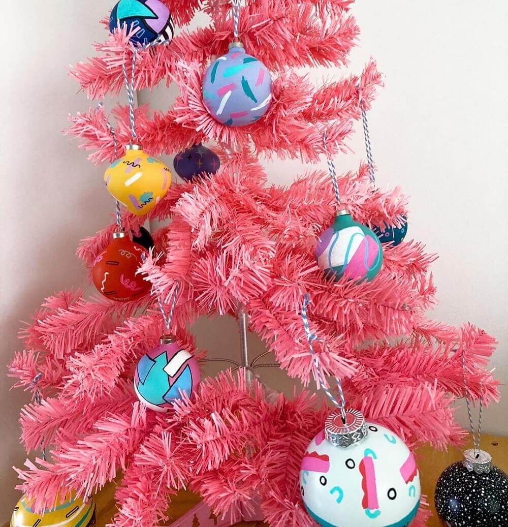 Pink Christmas tree with abstract baubles hanging from it.