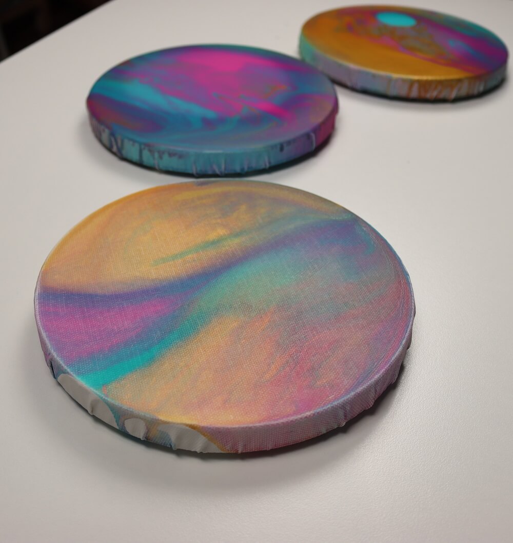 Three round canvases painted with galaxy colours.