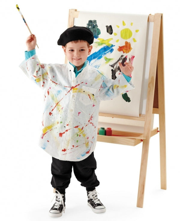 Child holding a paint brush, wearing a black beret and a messy art apron, standing in front of a painted easel.