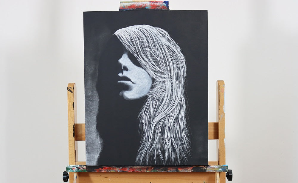 White charcoal drawing on canvas of a woman resting on an easel