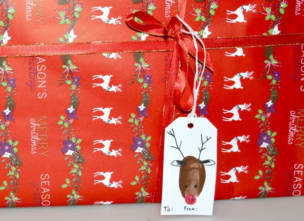 A red reindeer tag on a red Christmas gift.