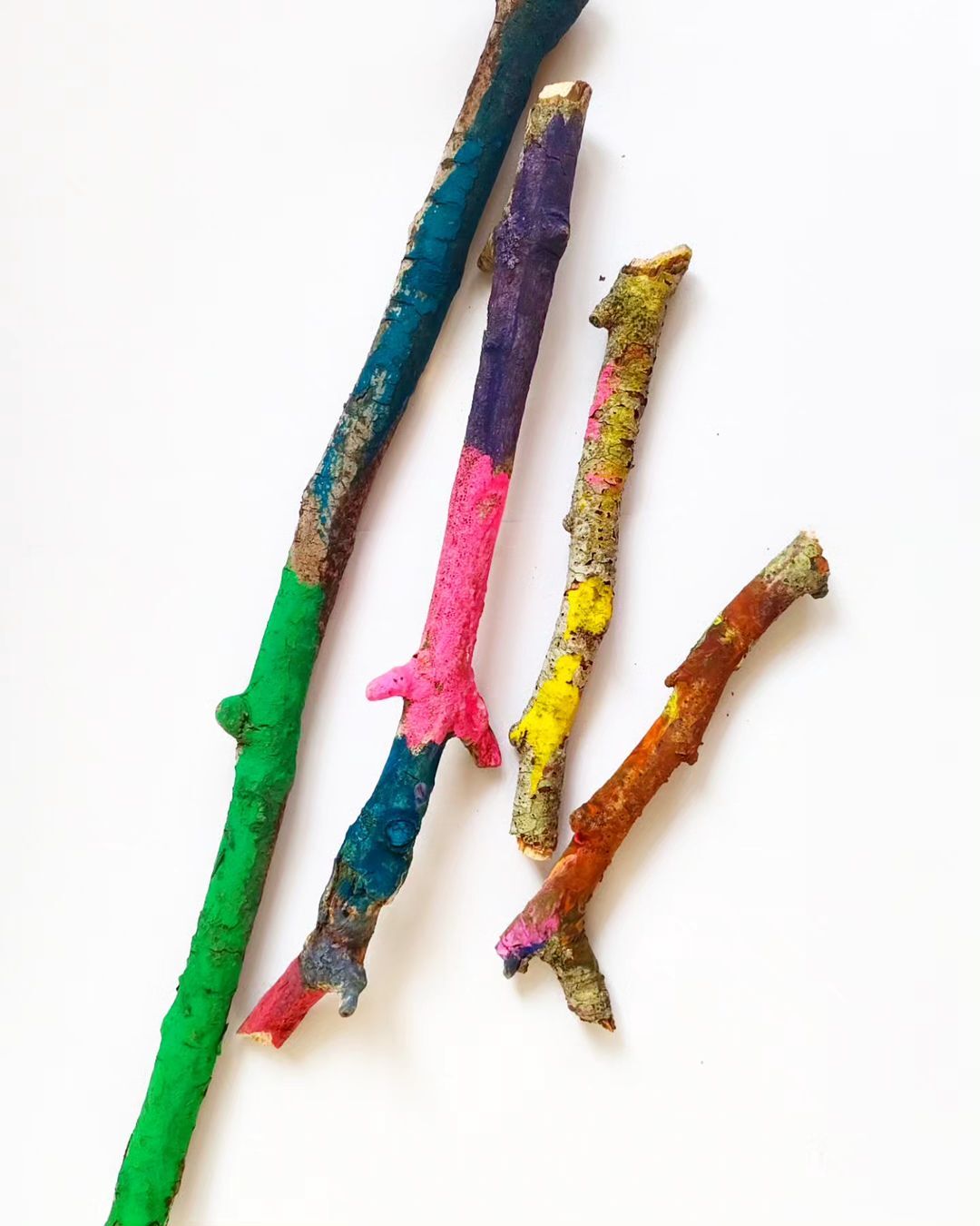 9. 4 painted sticks in various sizes and colours