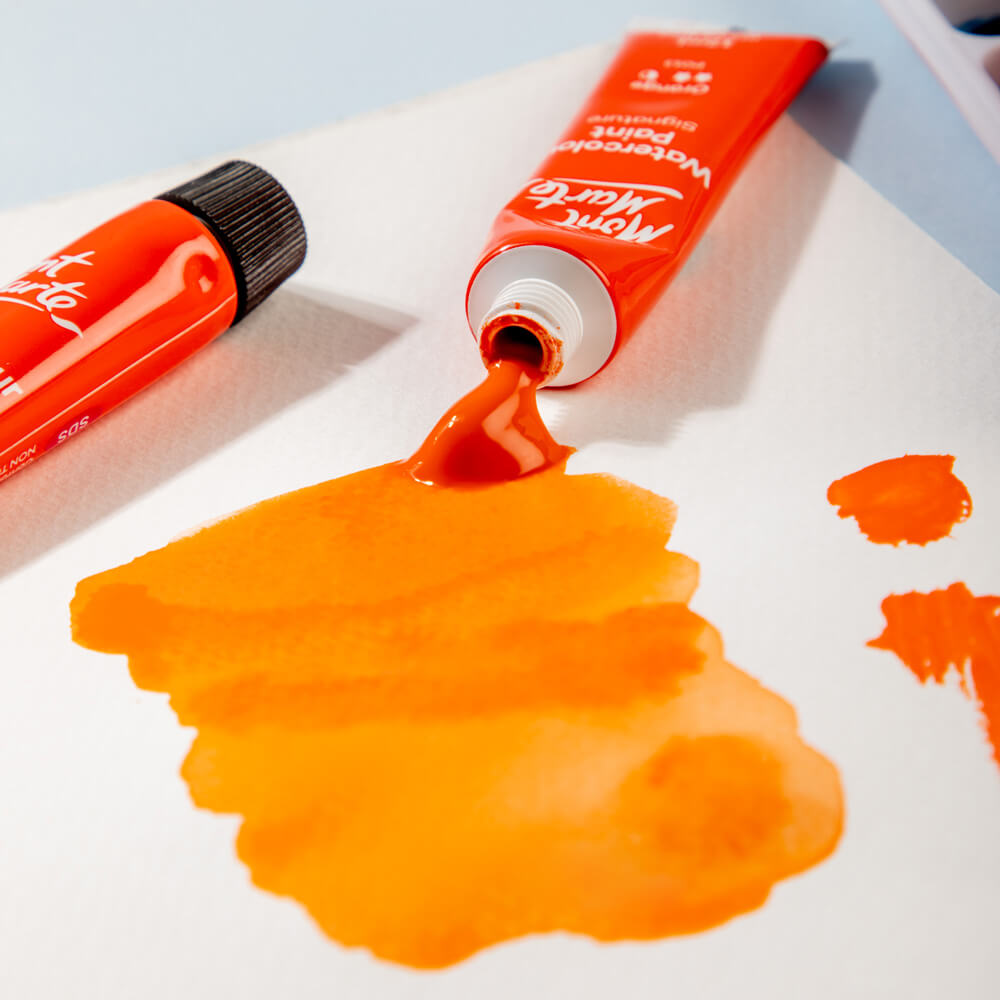 9. Orange watercolour paint tub with paint oozing out and dilutred paint
