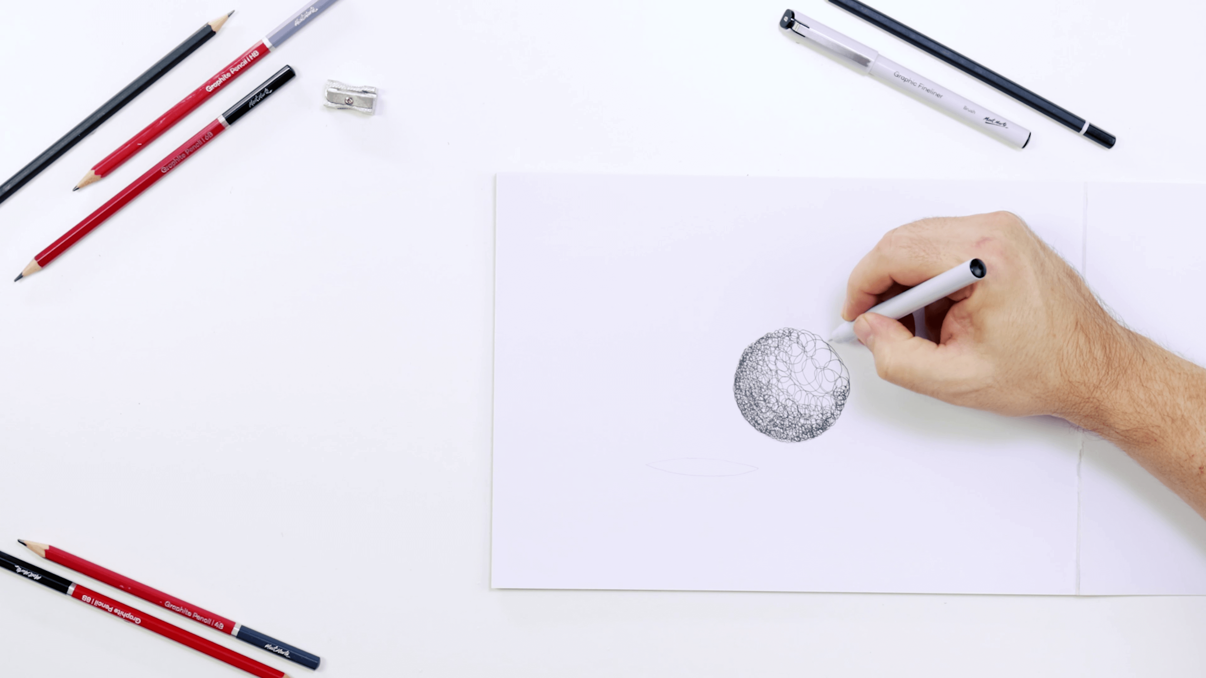 Pen scribbling lines in the form of a sphere.