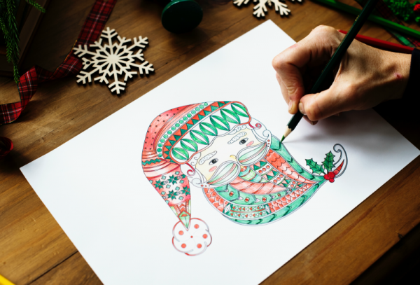 Hand colouring in a Santa face to create a Christmas card.