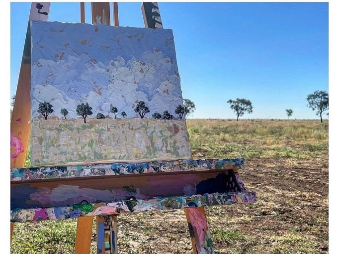 An abstract painting on a canvas in the outback on an easel.