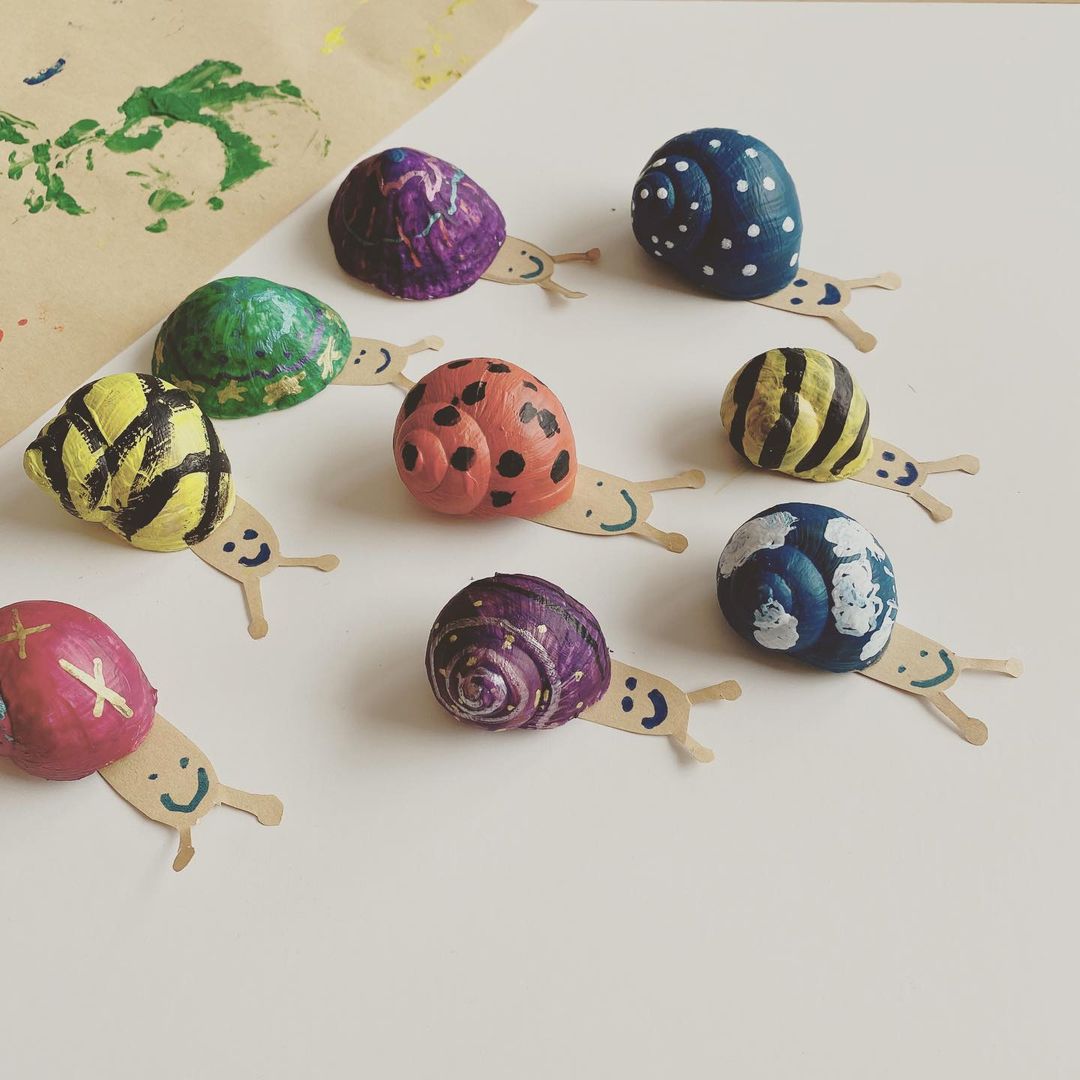 Brightly coloured rocks with patterns drawn on top with drawings to look like snails.