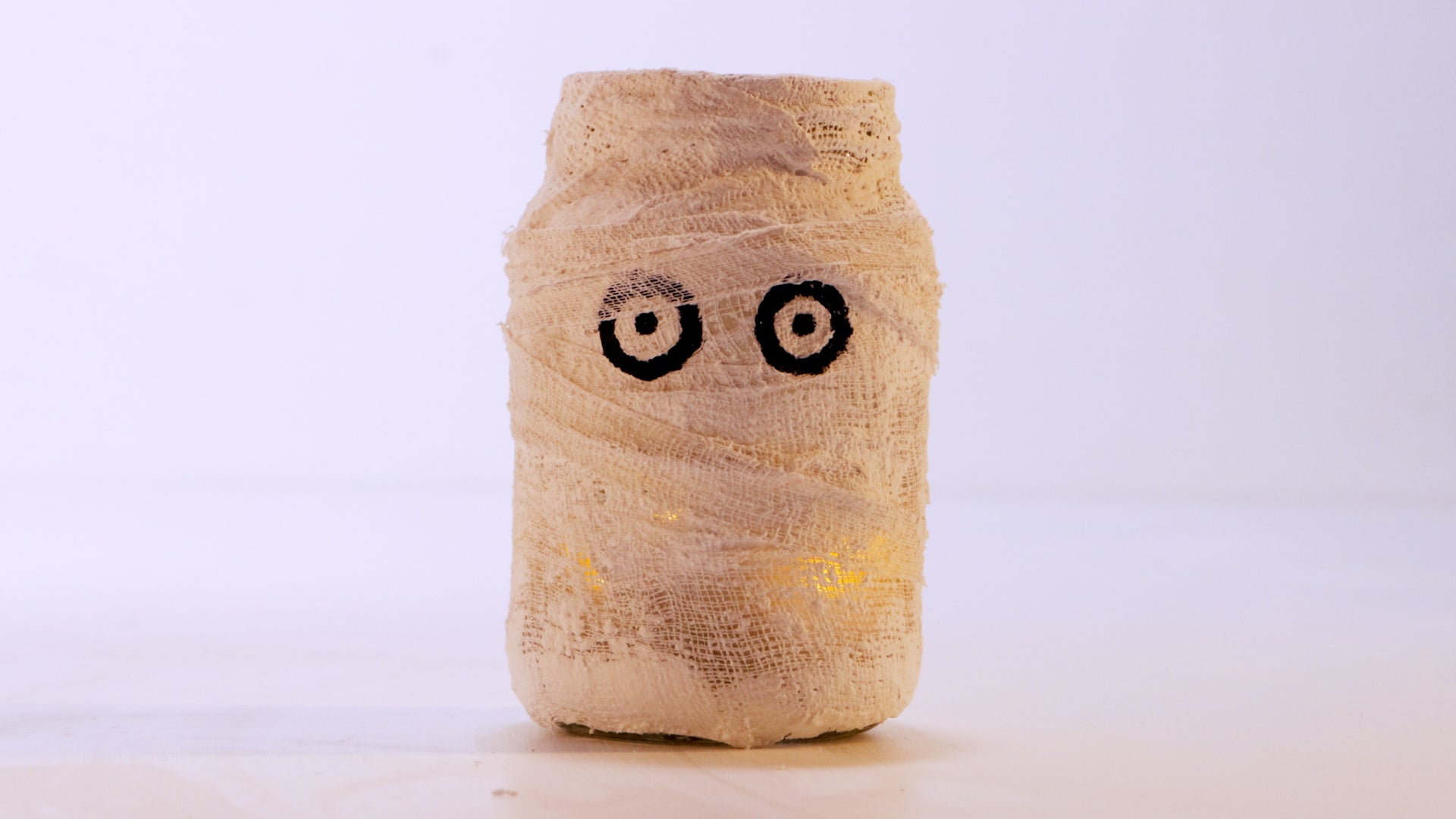 Mason jar wrapped in a bandage to look like a mummy lantern.