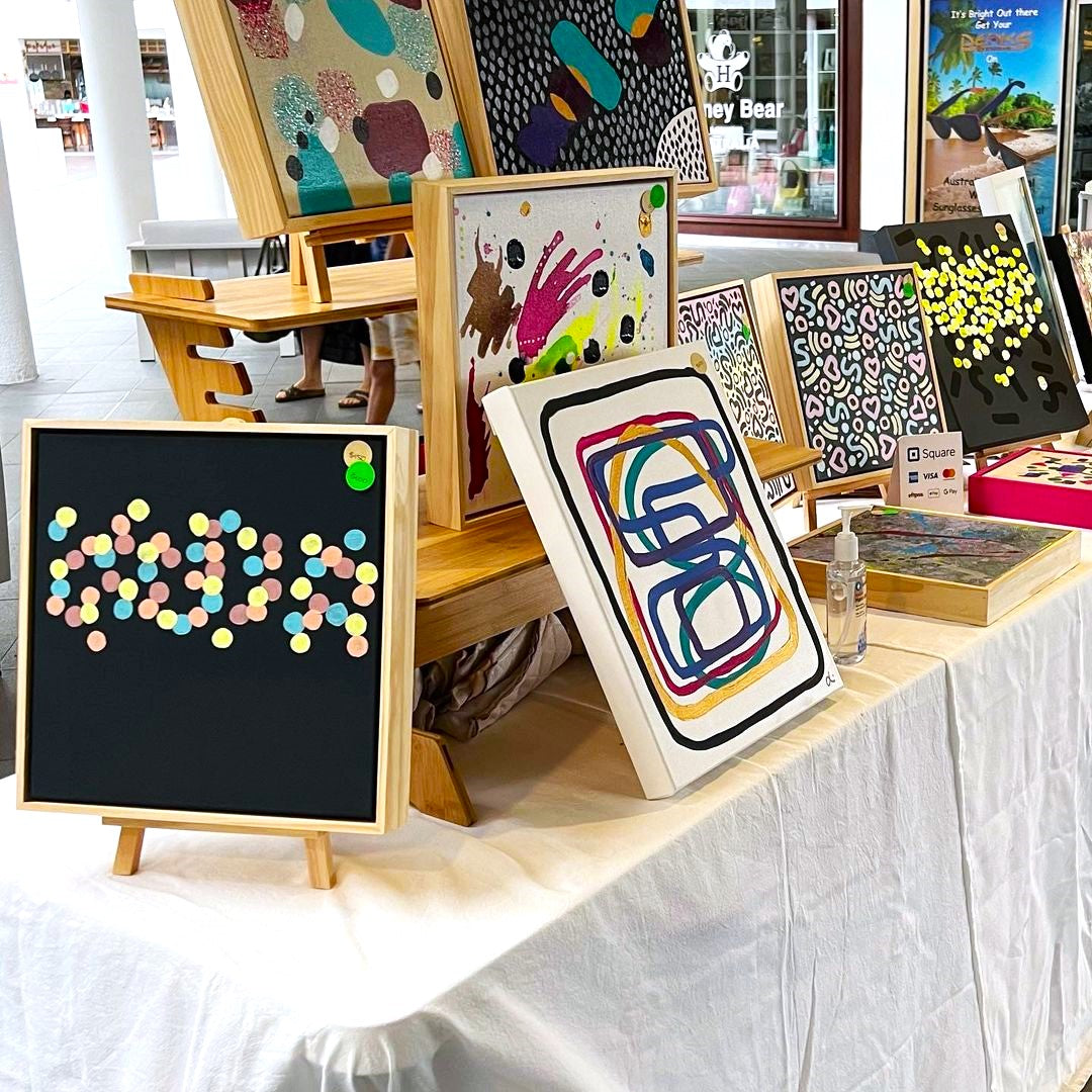 Lisa's paintings and crafts displayed at a market